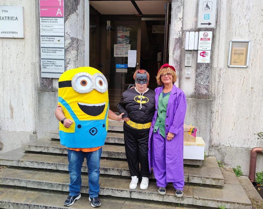 Delegazione in visita con costumi da supereroi e cartononi davanti all'ingresso